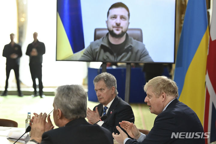 [런던=AP/뉴시스] 15일(현지시간) 런던에서 열린 북유럽 안보에 초점을 맞춘 합동원정군 지도자 회의(JEF)에서 젤렌스키 우크라이나 대통령이 화상으로 연설하자 참석자들이 박수를 치고 있다. 2022.03.16. *재판매 및 DB 금지