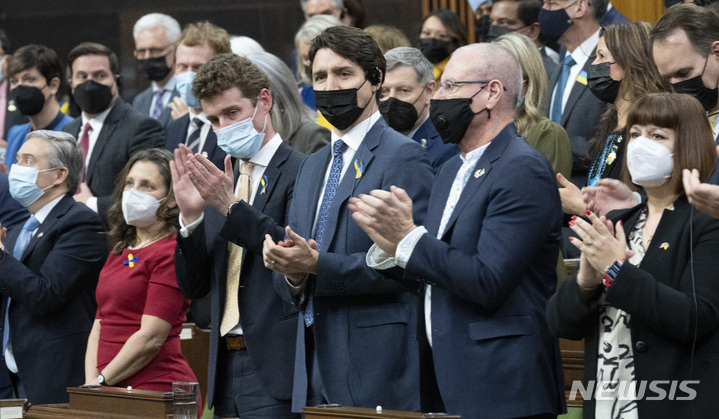 [오타와=AP/뉴시스] 쥐스탱 트뤼도(가운데) 캐나다 총리가 15일(현지시간) 볼로디미르 젤렌스키 우크라이나 대통령의 캐나다 하원에서의 화상 연설이 끝난 후 다른 의원들과 함께 기립박수하고 있다. 젤렌스키 대통령은 연설에서 우크라이나 영공에 대한 비행금지구역 설정을 거듭 요청했다. 2022.03.16.