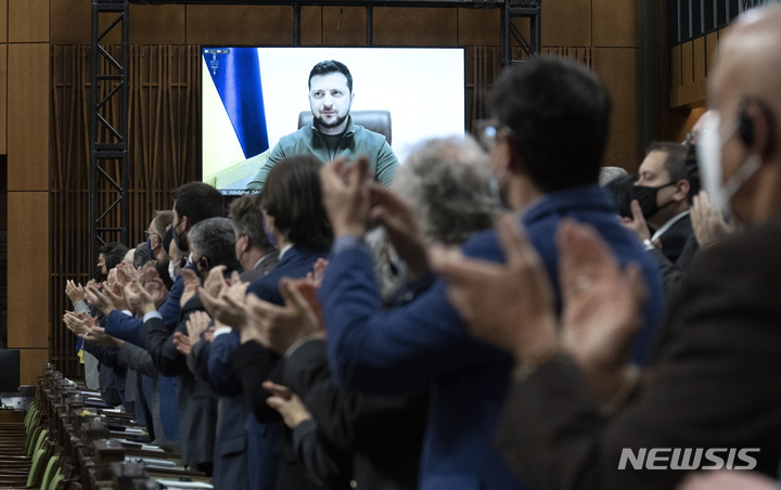 [오타와=AP/뉴시스] 볼로디미르 젤렌스키 우크라이나 대통령이 15일(현지시간) 화상을 통해 캐나다 하원 의회 연설을 마치고 의원들의 박수를 받고 있다. 젤렌스키 대통령은 연설에서 우크라이나 영공에 대한 비행금지구역 설정을 거듭 요청했다. 2022.03.16.