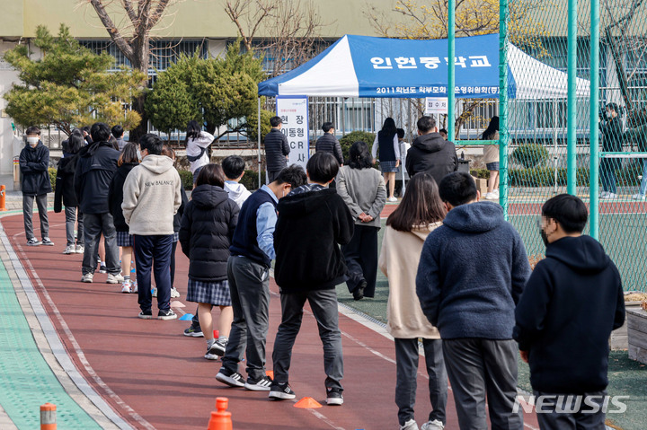 [서울=뉴시스] 홍효식 기자 =지난 16일 서울 관악구 인헌중학교에서 학생들이 코로나19 대응 현장 이동형 PCR(유전자증폭) 검사를 받기 위해 줄을 서고 있다. (공동취재사진) 2022.03.23. photo@newsis.com
