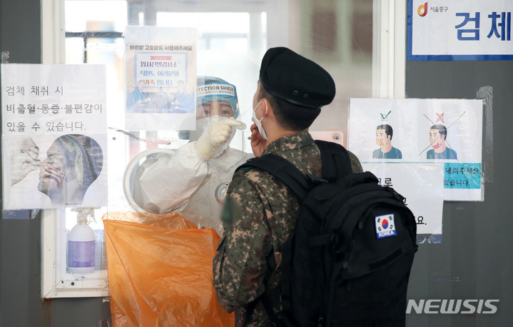 [서울=뉴시스] 홍효식 기자 = 지난 3월17일 서울역 광장에 마련된 중구 임시선별검사소에서 의료진이 군인의 검체를 채취하고 있다. (사진=뉴시스 DB). 2022.03.17. yesphoto@newsis.com