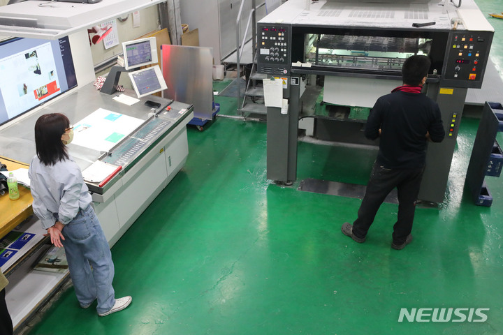 [파주=뉴시스] 배훈식 기자 = 박참새 작가가 17일 오후 경기 파주시의 한 인쇄소에서 자신의 첫번째 책 표지 인쇄를 바라보고 있다. 2022.03.30. dahora83@newsis.com