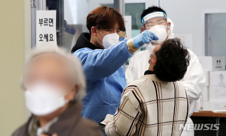 [서울=뉴시스] 홍효식 기자 = 0시 기준 코로나19 신규 확진자가 40만7017명 집계된 지난 18일 서울 송파구보건소 선별진료소에서 의료진이 시민들의 검체를 채취하고 있다. 2022.03.18. yesphoto@newsis.com