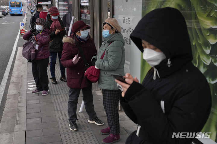 [베이징=AP/뉴시스] 17일 중국 베이징의 한 버스 정류장에 마스크를 쓴 주민들이 모여 버스를 기다리고 있다. 중국의 코로나19 확진자가 급증하는 가운데 시진핑 국가주석은 "버티는 것이 곧 승리"라며 '제로 코로나' 정책 유지를 강조했다. 2022.03.18.