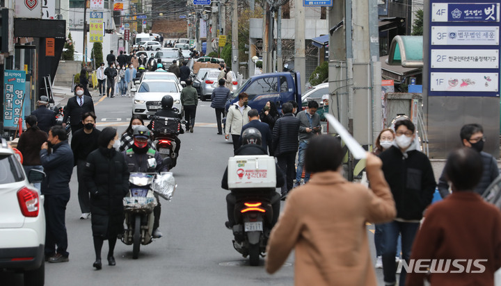 [서울=뉴시스] 권창회 기자 = 새로운 사회적 거리두기 조정 방안이 발표된 지난 18일 오후 서울 시내 식당가에서 시민들이 식사를 위해 이동하고 있다. 오는 21일부터 다음 달 3일까지 코로나19 백신 접종 여부와 관계없이 전국 어디서나 8명까지 모임이 가능하다. 다중이용시설 이용 시간은 종전처럼 오후 11시까지다. 2022.03.18. kch0523@newsis.com