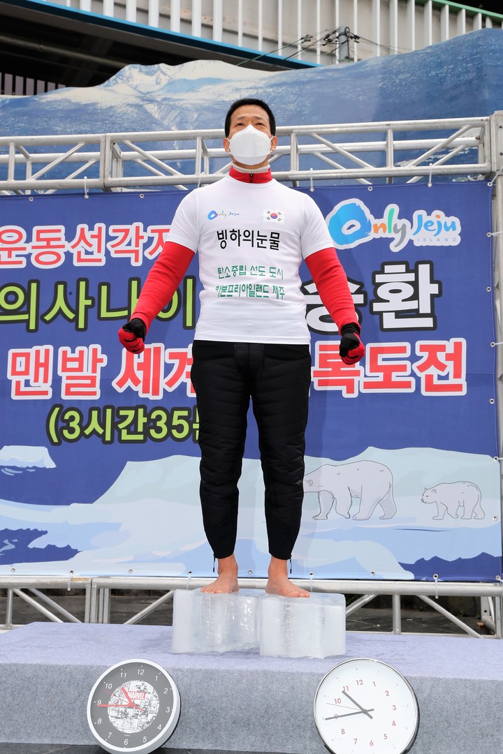 [제주=뉴시스] 양영전 기자 = ‘얼음 위 맨발로 오래 서 있기’ 세계신기록 보유자인 조승환씨가 20일 제주시 연동 누웨마루 거리에서 열린 '탄소 없는 섬 2030(CFI 2030)' 정책 홍보 캠페인에서 또다시 세계기록 경신에 성공한 뒤 기념 촬영을 하고 있다. 조씨는 이날 기존 본인 기록을 5분 늘려 3시간35분으로 기록을 경신했다. (사진=제주도 제공) 2022.3.20. photo@newsis.com *재판매 및 DB 금지