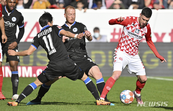 [마인츠=AP/뉴시스] 마인츠05의 아론 마르틴(오른쪽)이 19일(한국시간) 독일 마인츠에서 열린 분데스리가 홈경기에서 아르미니아 빌레펠트의 오쿠가와 마사야와 볼다툼을 하고 있다. 2022.03.20.