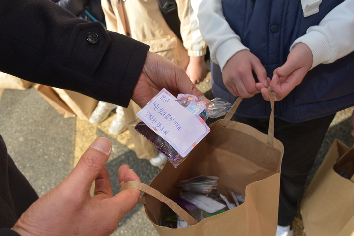 [울산=뉴시스] 구미현 기자 = 21일 울산 동구에 정착한 아프가니스탄 특별기여자 자녀들이 첫 등교를 시작한 가운데 반 친구에게 나눠 줄 과자 선물을 취재진에게 보여주고 있다. 2022.03.21. gorgeouskoo@newsis.com *재판매 및 DB 금지