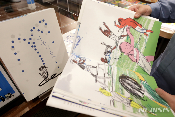 [서울=뉴시스] 박진희 기자 = 한스 크리스티안 안데르센상(이하 안데르센상) 일러스트레이터 부문 수상자 이수지 작가의 그림책 '여름이 온다'를 22일 서울 종로구 교보문고 직원이 살펴보고 있다. 이 작가는 한국인 최초로 '아동문학계 노벨상'인 안데르센상을 수상했다. 이번에 수상 작품 '여름이 온다'는 물놀이와 비발디의 '사계' 중 '여름 1~3악장'을 연결한 아름다운 그림책이다. 2022.03.22. pak7130@newsis.com