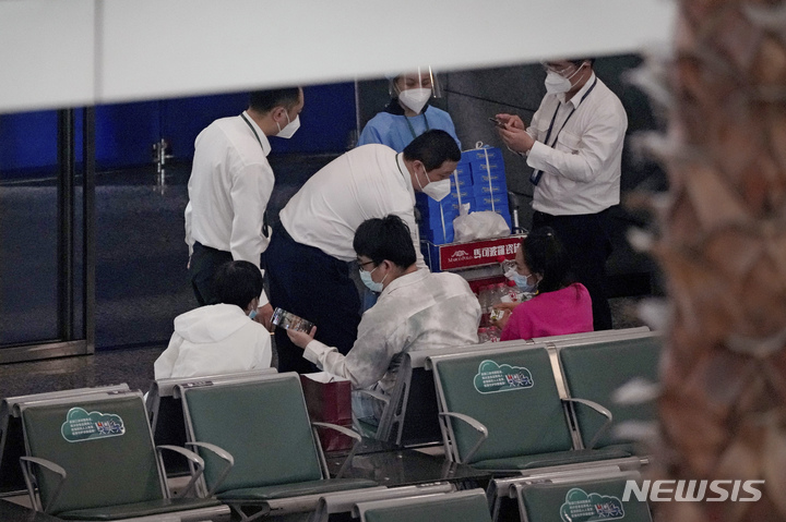 [광저우=AP/뉴시스] 22일(현지시간) 중국 광둥성 광저우의 바이윈 국제공항 관계자들이 전날 추락한 중국 동방항공 소속 MU5735편 탑승자 가족 통제구역에서 물 등을 나눠주고 있다. 구조대는 승객 등 132명이 탑승한 보잉 737기 추락 현장에서 수색을 이어가면서 지금까지 생존자는 발견되지 않았다고 밝혔다. 2022.03.22. 