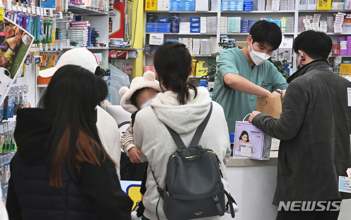 [수원=뉴시스] 김종택기자 = 코로나19 확진자가 급증하면서 감기약과 해열제 수요가 급증하고 있는 22일 오후 경기도 수원시 한 약국에 감기약을 구입하려는 시민들로 붐비고 있다. 2022.03.22. jtk@newsis.com