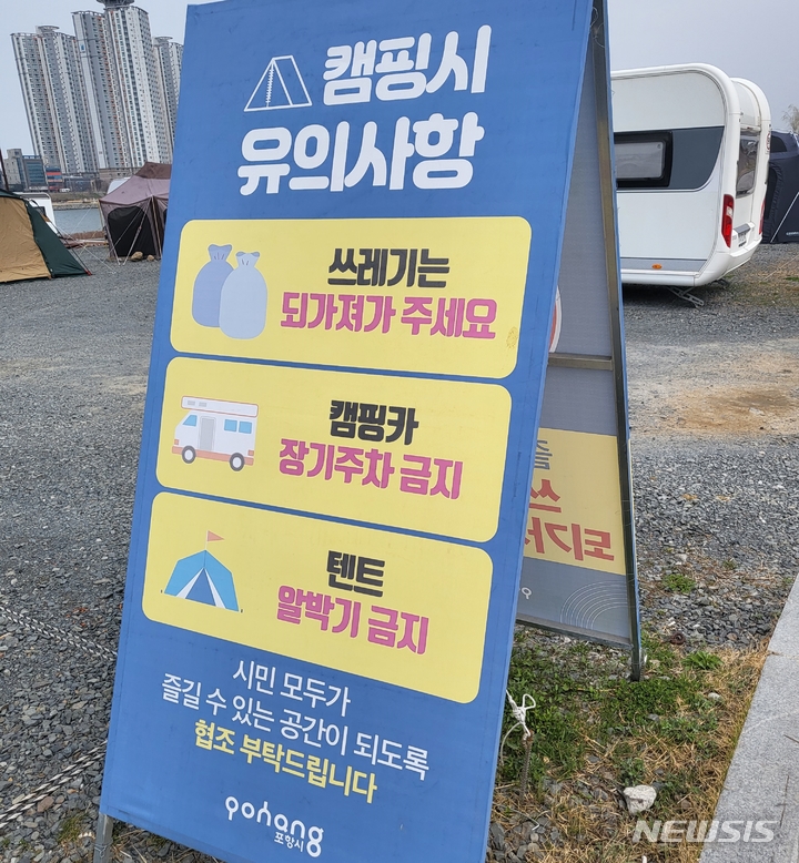 [포항=뉴시스] 이바름 기자 = 경북 포항시 남구 연일읍 형산강변에 설치된 캠핑카 장기주차·텐트 알박기 금지 알림판. 2022.03.23. right@newsis.com