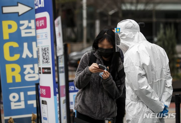 [서울=뉴시스] 정병혁 기자 = 국내 코로나19 누적 확진자가 1000만명을 넘어선 23일 오전 서울 송파구 보건소에 설치된 선별진료소를 찾은 시민이 의료진의 안내를 받고 있다. 2022.03.23. jhope@newsis.com