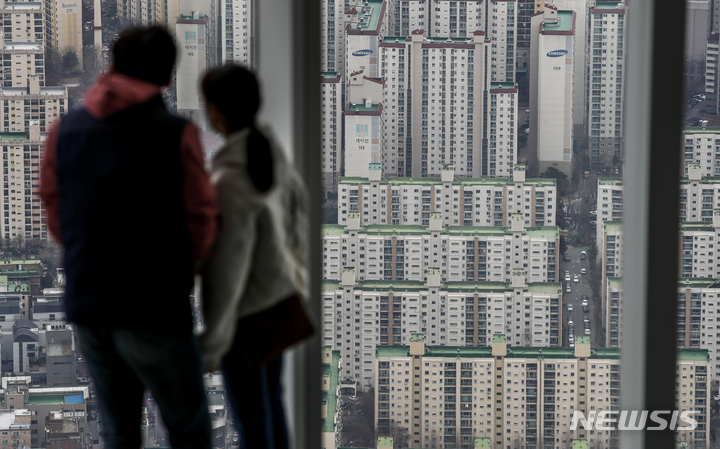 [서울=뉴시스] 정병혁 기자 = 서울 송파구 롯데월드타워 전망대 서울스카이를 찾은 시민들이 서울 도심을 바라보고 있다. 2022.03.23. jhope@newsis.com