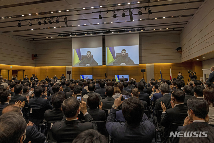 [도쿄=AP/뉴시스] 볼로디미르 젤렌스키 우크라이나 대통령이 23일 화상을 통해 일본 의회에서 연설하는 모습을 지켜보던 일본 의원들이 박수하고 있다. 2022.03.23.