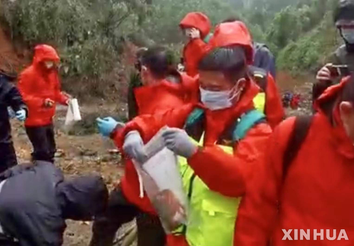 [우저우(광시)=신화/뉴시스] 23일 중국 광시좡족자치구 우저우의 동방항공 여객기 추락 사고 현장에서 관계자가 수거된 블랙박스는 비닐봉투에 담고 있다. 2022.03.24 