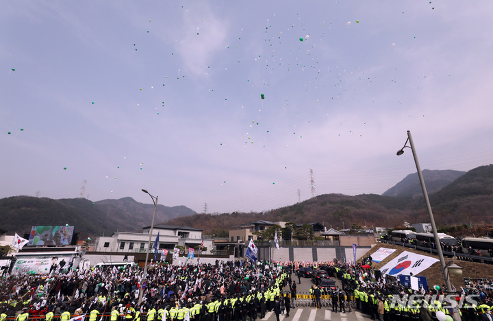 [대구=뉴시스] 이영환 기자 = 박근혜 전 대통령이 탑승한 차량이 24일 오후 대구 달성군 유가읍 박 전 대통령 사저에 도착하자 시민들이 환호하고 있다. 2022.03.24. 20hwan@newsis.com