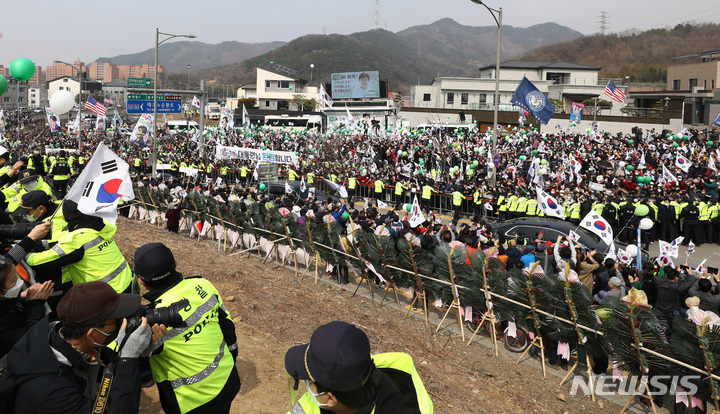 [대구=뉴시스] 이영환 기자 = 박근혜 전 대통령이 탑승한 차량이 24일 오후 대구 달성군 유가읍 박 전 대통령 사저에 도착하자 시민들이 환호하고 있다. 2022.03.24. 20hwan@newsis.com