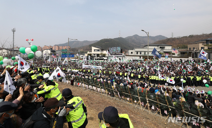 [대구=뉴시스] 이영환 기자 = 박근혜 전 대통령이 탑승한 차량이 24일 오후 대구 달성군 유가읍 박 전 대통령 사저에 도착하자 시민들이 환호하고 있다. 2022.03.24. 20hwan@newsis.com