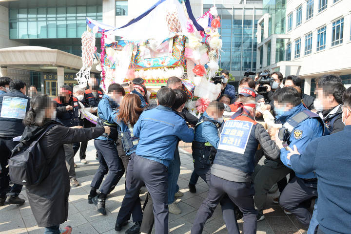 [울산=뉴시스] 배병수 기자 = 공공운수노조 조합원들이 24일 오전 울산시청 햇빛광장에서 숨진 조합원의 상여를 메고 광장으로 들어오자 시청 직원들이 제지하는 과정에서 충돌이 빚어지고 있다. 2022.03.23. bbs@newsis.com
