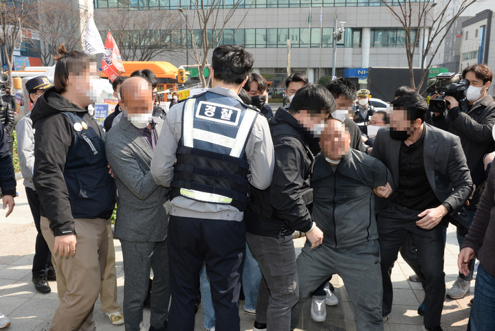 [울산=뉴시스] 배병수 기자 = 24일 오전 울산시청 정문앞에서 공공운수노조 조합원이 분신을 시도하다 경찰에 연행되고 있다. 2022.03.24. bbs@newsis.com