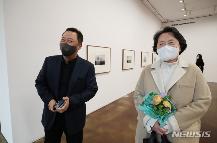 [서울=뉴시스] 조수정 기자 = 경영인이자 사진가인 박용만 전 대한상의 회장이 '첫사랑' 아내 강신애 여사와 24일 서울 종로구 국제갤러리 K2에서 열린 '오! 라이카'(O! Leica) 2022 전시를 찾아 자신의 작품 앞에서 대화 나누고 있다. 이번 전시는 박 전 회장, 라이카 엠버서더 배우 류준열, 포토저널리스트 신웅재,&nbsp; 20세기 초현실주의 사진 거장 랄프 깁슨, 미국계 한국인인 '앰부쉬' 패션 디자이너 윤 안, 버추얼 아티스트 웨이드의 사진을 보여준다. 6인의 라이카 아티스트는 일상이 되어버린 팬데믹의 중첩된 장면과 다시 만날 빛과 희망을 라이카 M 카메라 시스템으로 담아냈다. 전시는 25일부터 다음 달 1일까지. 2022.03.24. chocrystal@newsis.com