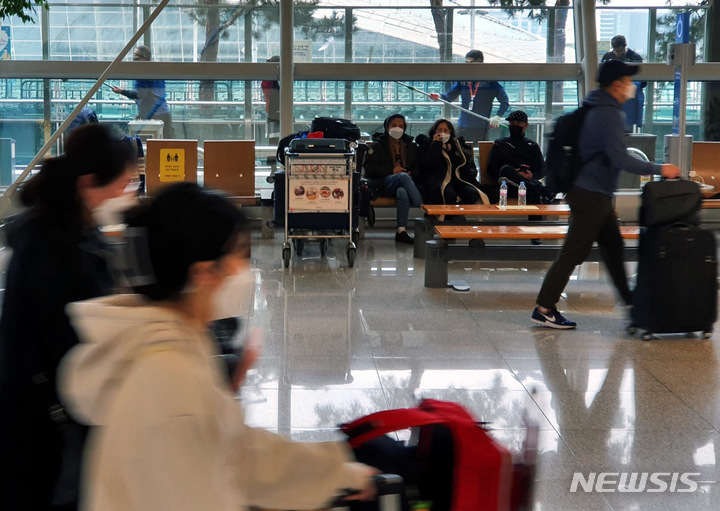 [인천공항=뉴시스] 홍찬선 기자 = 지난 25일 인천공항 제1여객터미널 출국장에서 코로나 19 이후 늘어난 승객들 사이로 환경미화원들이 유리창을 닦으며 앞으로의 일상회복을 준비하고 있다. 2022.03.27. mania@newsis.com  