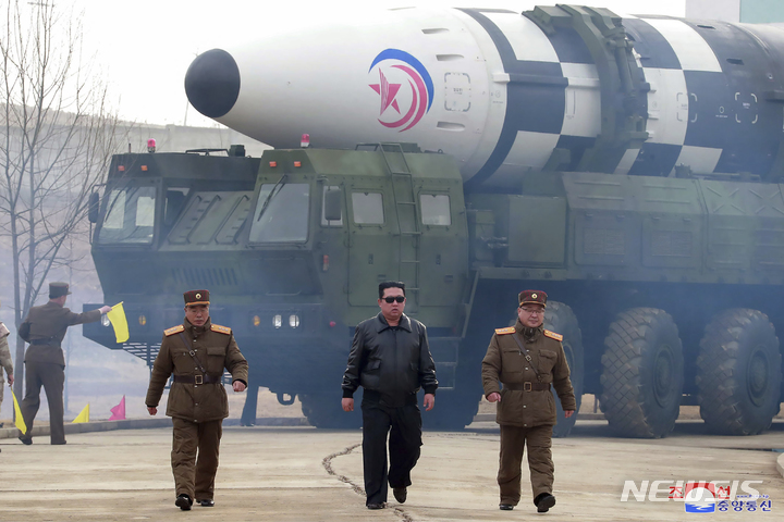 [평양=AP/뉴시스] 북한 조선중앙통신이 공개한 사진에 김정은(가운데) 북한 국무위원장이 24일 장소가 알려지지 않은 곳에서 발사대에 실린 화성-17 대륙간탄도미사일(ICBM)을 둘러보고 있다. 2022.03.25.