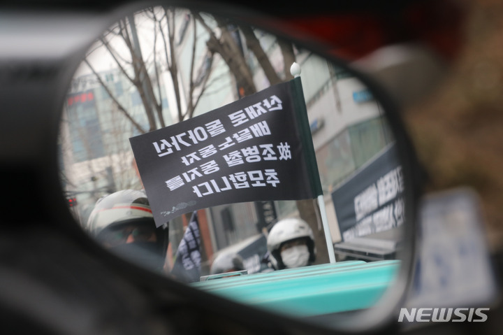 [서울=뉴시스] 권창회 기자 = 25일 오전 서울 강남구 신논현역 인근 교보타워 사거리에서 열린 고(故) 조병철 배달노동자 노제에서 고인 추모 깃발이 펄럭이고 있다. 고인은 지난 9일 교보타워 사거리에서 운행 도중 신호위반 하던 택시와 충돌해 숨졌다. 2022.03.25. kch0523@newsis.com