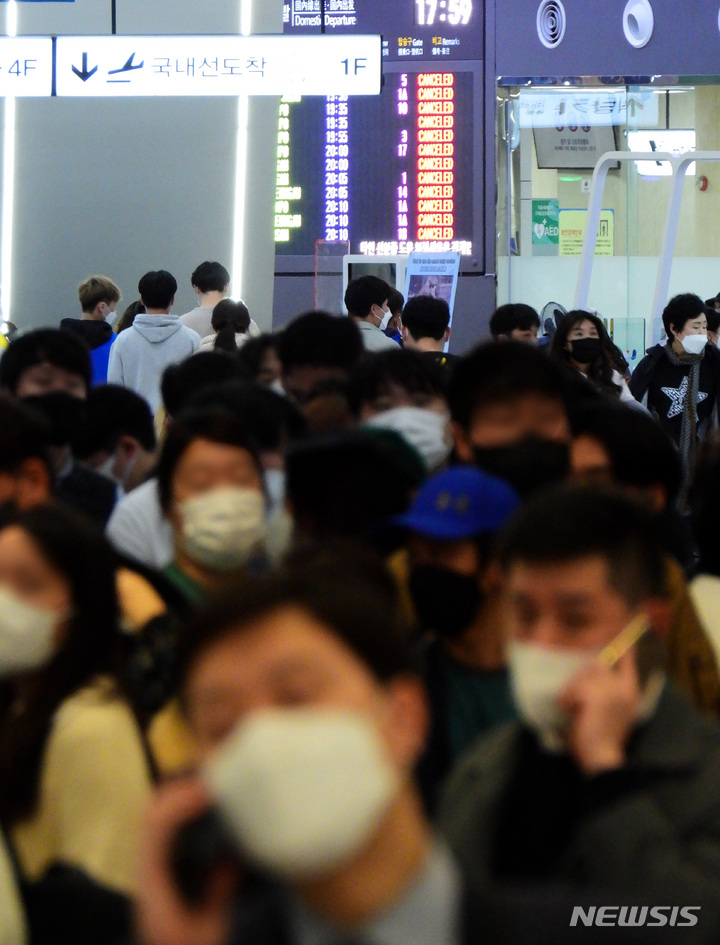 [제주=뉴시스] 우장호 기자 = 제주 지역 기상이 악화하고 있는 25일 오후 제주국제공항 3층 출발장에 항공기 운항 정보를 확인하려는 이용객들이 몰리면서 혼잡한 모습을 하고 있다. 2022.03.25. woo1223@newsis.com