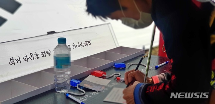 [대구=뉴시스] 이지연 기자 = 26일 오후 대구 달성군 유가읍 쌍계리의 위치한 박근혜 전 대통령 사저 앞을 찾은 한 시민이 응원 엽서를 쓰고 있다. 2022.03.26. ljy@newsis.com