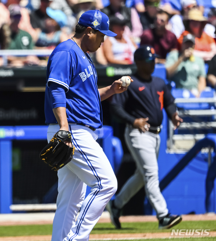 [더니든=AP/뉴시스] 토론토 블루제이스의 류현진이 26일(한국시간) 미국 플로리다주 더니든에서 열린 디트로이트 타이거스와 2022 MLB 스프링캠프 시범경기 1회초에서 선두타자 아킬 바두에게 솔로 홈런을 허용한 뒤 주심으로부터 새로 받은 공을 바라보고 있다. 2022.03.26.