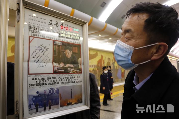 [평양=AP/뉴시스] 2022년 3월 25일 북한 평양 개선역에서 한 남성이 노동신문을 보고 있다. 2025.12.30. 