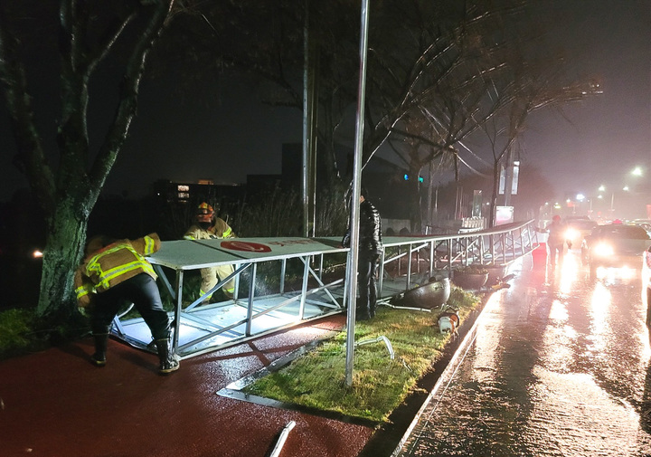 [제주=뉴시스] 우장호 기자 = 강풍경보가 발효되는 등 기상이 악화한 제주 지역에 관련 피해도 잇따랐다. 지난 25일 오후 제주시 노형동의 한 도로에 설치된 아치형 광고 구조물이 바람에 쓰러져 출동한 제주소방서 소속 대원들이 안전조치를 하고 있다. (사진=제주소방서 제공) 2022.03.26. woo1223@newsis.com *재판매 및 DB 금지