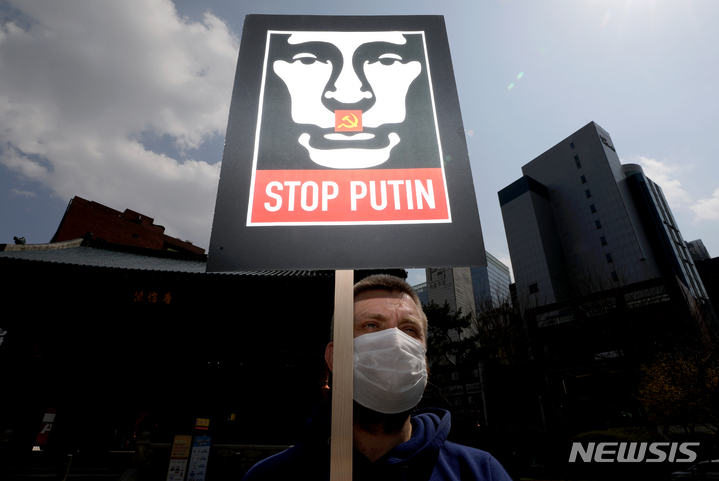 [서울=뉴시스] 김병문 기자 = 재한 러시아인이 지난달 27일 오후 서울 종로구 보신각 앞에서 열린 우크라이나 전쟁을 반대하는 집회에서 팻말을 들고 있다. 2022.03.27. dadazon@newsis.com