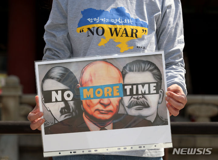 [서울=뉴시스] 김병문 기자 = 재한 러시아인이 지난 27일 오후 서울 종로구 보신각 앞에서 열린 우크라이나 전쟁을 반대하는 집회에서 팻말을 들고 있다. 2022.03.27. dadazon@newsis.com