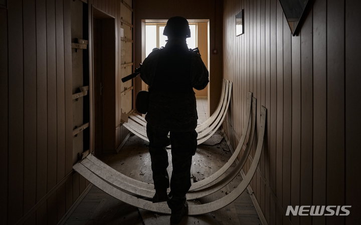 [스토얀카=AP/뉴시스] 27일(현지시간) 우크라이나 스토얀카에서 우크라이나 군인이 심하게 훼손된 건물 안을 살피고 있다. 2022.03.28.