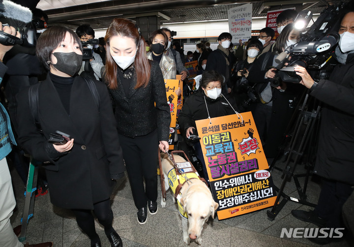 [서울=뉴시스] 권창회 기자 = 김예지 국민의힘 의원과 전국장애인차별연대 소속 회원들이 28일 오전 서울 종로구 경복궁역 3호선 승강장에서 장애인 이동권 보장·장애인 권리예산 반영을 요구하며 출근 시간대 지하철 시위를 하고 있다. 2022.03.28. kch0523@newsis.com