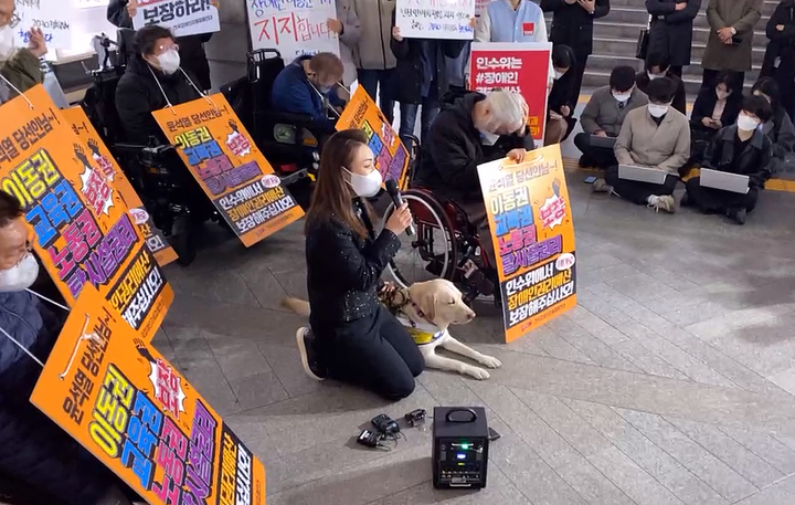 [서울=뉴시스] 김예지 국민의힘 의원이 지난 28일 서울 지하철 3호선 경복궁역에서 열린 전국장애인차별철폐연대(전장연)의 25차 '출근길 지하철 탑니다' 시위에 참석해 무릎을 꿇고 사과하고 있다. (사진=전장연 페이스북 캡쳐) 2022.03.28. photo@newsis.com *재판매 및 DB 금지