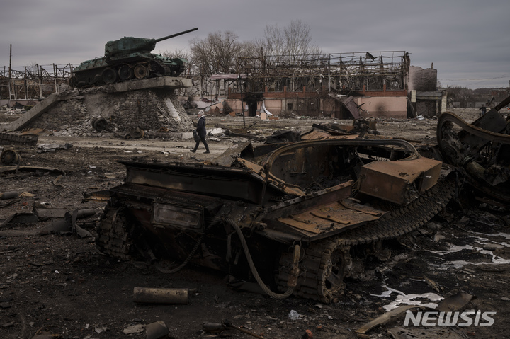 [트로스얀네츠=AP/뉴시스] 28일(현지시간) 우크라이나 트로스얀네츠 마을에서 한 주민이 파괴된 러시아군 전차 옆을 지나가고 있다. 우크라이나는 러시아군에 점령됐던 트로스얀네츠를 이틀 전 탈환했다. 2022.03.29.