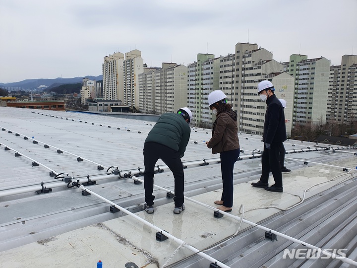[용인=뉴시스]용인시 관계자들이 마평동 용인실내체육관 지붕에 설치된 살수장치를 점검하고 있다.