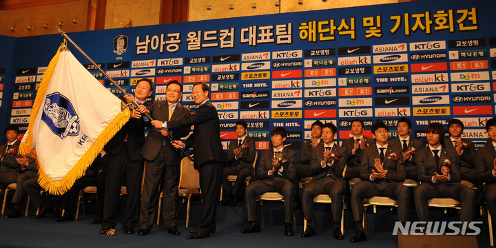 【서울=뉴시스】2010 남아공월드컵에서 첫 원정 16강의 쾌거를 이룩한 대한민국 축구대표팀이 29일 오후 귀국, 소공동 롯데호텔에서 해단식 및 기자회견을 가졌다. 노흥섭 선수단장, 조중연 대한축구협회장, 허정무 감독이 단기를 흔들고 있다. 2010.06.29. (사진 = 뉴시스DB)