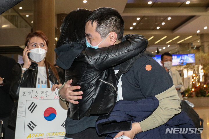 [인천공항=뉴시스] 조성우 기자 = 우크라이나 현지 고려인 동포 이스타니슬라브(23)씨가 지난해 3월30일 인천국제공항 제1여객터미널을 통해 입국해 엄마 손 알로나(46), 아빠 이블라디미르(52)씨와 인사를 나누고 있다. (공동취재사진) 2022.03.30. photo@newsis.com