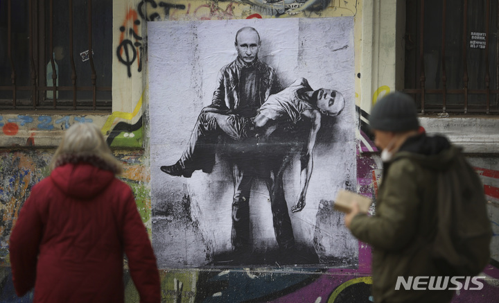 [소피아=AP/뉴시스] 3월 31일(현지시간) 불가리아 수도 소피아에서 시민들이 블라디미르 푸틴 러시아 대통령이 자신의 시신을 들고 있는 벽화 앞을 지나고 있다. 이 벽화는 불가리아 화가가 그린 것으로 알려졌다. 2022.04.01.