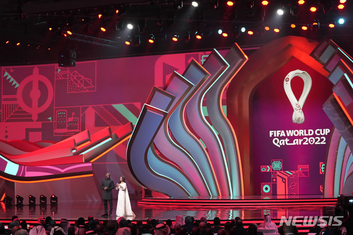 [도하=AP/뉴시스] 영화배우 이드리스 엘바(왼쪽)와 스포츠 방송인 레시민 초드후리가 2일(한국시간) 카타르 도하의 도하 전시컨벤션센터(ECC)에서 열린 2022 FIFA 카타르 월드컵 조 추첨행사에서 사회를 보기 위해 무대에 등장하고 있다. 2022.04.02.