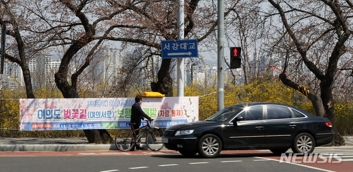 [서울=뉴시스] 고범준 기자 = 3일 서울 영등포구 윤중로 벚꽃길(여의서로) 거리에 보행로 개방 관련 현수막이 걸려 있다. 영등포구는 개화 시기가 늦어지면서 여의도 벚꽃길 개방 날짜를 오는 9일부터 17일까지 변경했다. 하루 전날인 4월8일 정오부터 4월18일 정오까지는 교통통제가 시행된다. 2022.04.03. bjko@newsis.com