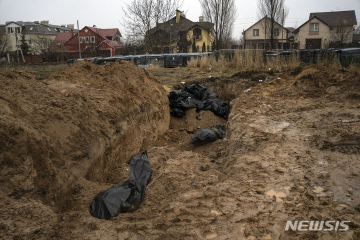 [부차=AP/뉴시스] 3일(현지시간) 우크라이나 키이우 인근 부차(Bucha)에서 숨진 사람들의 시신이 집단 매장되고 있다. 우크라이나 당국은 키이우 인근 지역에서 민간인 시신 410구를 수습했다고 밝혔다. 2022.04.04.
