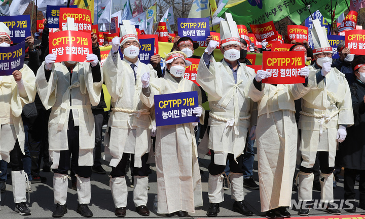 [서울=뉴시스] 이영환 기자 = 4일 오후 서울 영등포구 여의도 산업은행 인근 인도에서 열린 CPTPP(포괄적점진적 환태평양경제동반자협정) 저지 한국 농어민 총궐기대회에서 참석자들이 구호를 외치고 있다. 2022.04.04. 20hwan@newsis.com