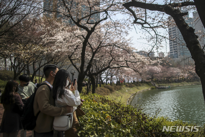 [서울=뉴시스] 정병혁 기자 = 완연한 봄 날씨를 보인 4일 오후 서울 송파구 석촌호수를 찾은 시민들이 벚꽃길을 걸으며 시간을 보내고 있다. 2022.04.04. jhope@newsis.com