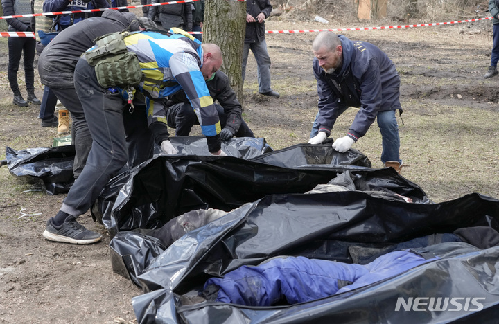 [키이우(우크라이나)= AP/뉴시스] 키이우 교외의 부챠 주민 자원봉사자들이 러시아 군에 의해 손이 뒤로 묶인 채 살해된 민간인들의 시신을 수습하고 있다.&nbsp; 